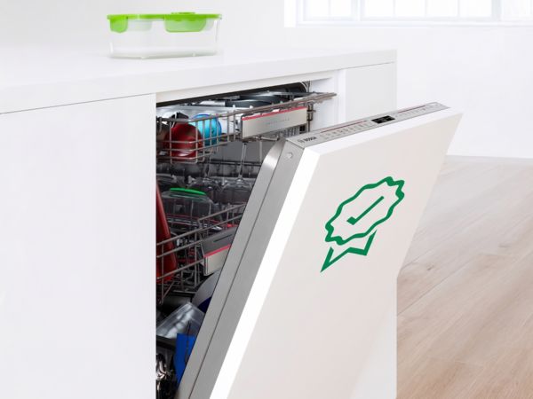 Halb ge&ouml;ffneter Einbau-Geschirrsp&uuml;ler mit gr&uuml;nem Zertifikatslogo auf der T&uuml;r, best&uuml;ckt mit Geschirr und Besteck.