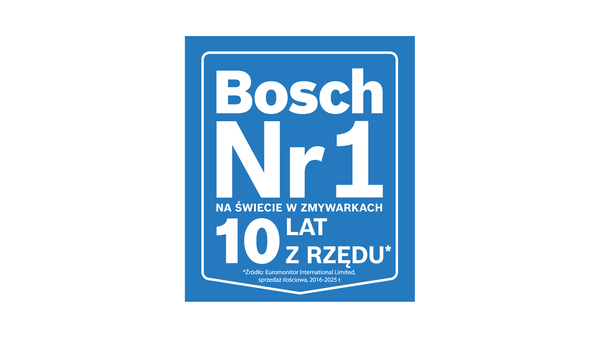 Otwarta zmywarka z czystymi naczyniami, sztućcami i środkami czystości, w jasnym pomieszczeniu z drewnianą podłogą i rośliną.