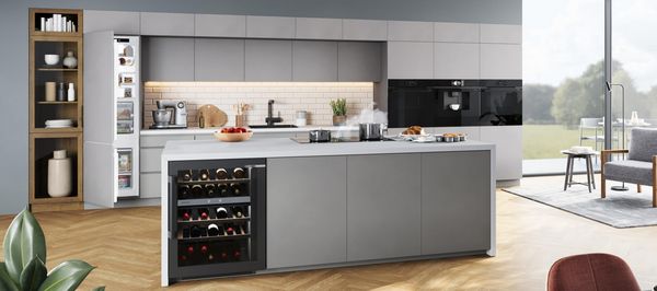 Bilden visar ett modernt gr&aring;tt k&ouml;k med k&ouml;ks&ouml; och integrerade vitvaror fr&aring;n Bosch.