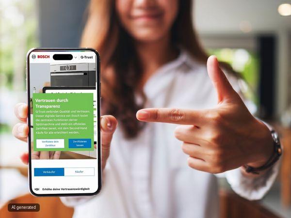 Eine Frau zeigt auf ein Smartphone, das das Bosch Q‑Trust‑Zertifikat anzeigt; unscharfer K&uuml;chenhintergrund.