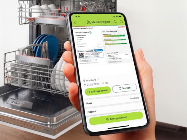 Hand h&auml;lt Smartphone mit Kleinanzeigen-App und Bosch Q-Trust Zertifikat vor offenem, beladenem Geschirrsp&uuml;ler.