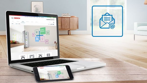 En b&auml;rbar dator och smartphone visar en enkel e-postikon i ett ljust, modernt vardagsrum. 