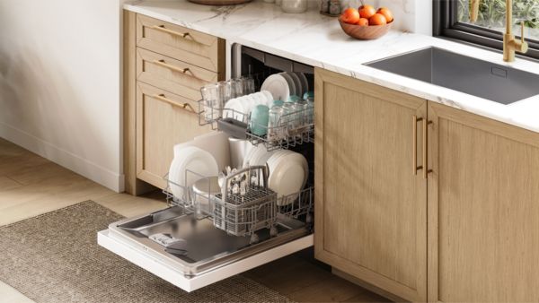 En smartphone och laptop p&aring; ett tr&auml;bord visar en samtalsikon, bredvid ett glas kaffe i ett ljust, minimalistiskt rum 