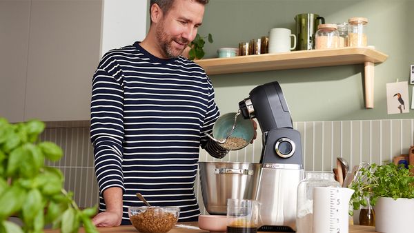 Ein Mann verarbeitet mit der Bosch K&uuml;chenmaschine Serie 6 Lebensmittel in einer K&uuml;che, um sich gesund zu ern&auml;hren und sein Mikrobiom zu st&auml;rken.