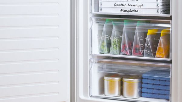 Congelatore Bosch No Frost aperto con cassetti contenenti sacchetti di alimenti, contenitori e vaschette per ghiaccio