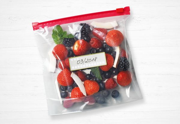 Sacchetto per alimenti con chiusura ermetica contenente frutti di bosco e pezzi di cocco, con etichetta della data