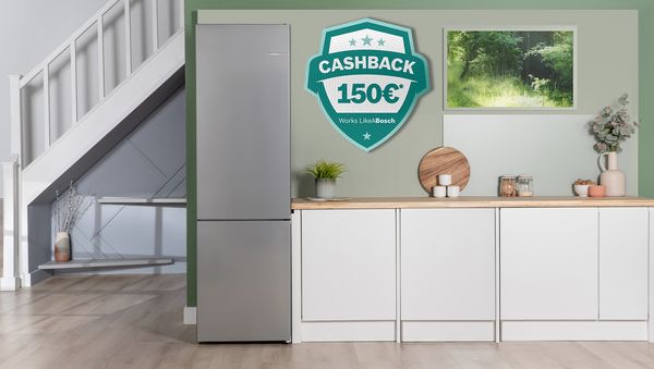 Un frigorifero moderno in acciaio inox in una cucina elegante, con un'offerta di cashback di 100&euro;. Spazio luminoso e accogliente con piante. 