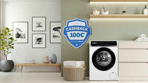 Una moderna lavatrice bianca accanto a uno scaffale di asciugamani, con un cartello promozionale "200&euro; Cashback".