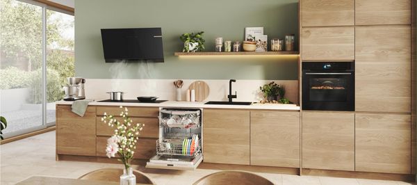 Bilden visar ett tr&auml;k&ouml;k med k&ouml;ksluckor i ek och vitvaror fr&aring;n Bosch.