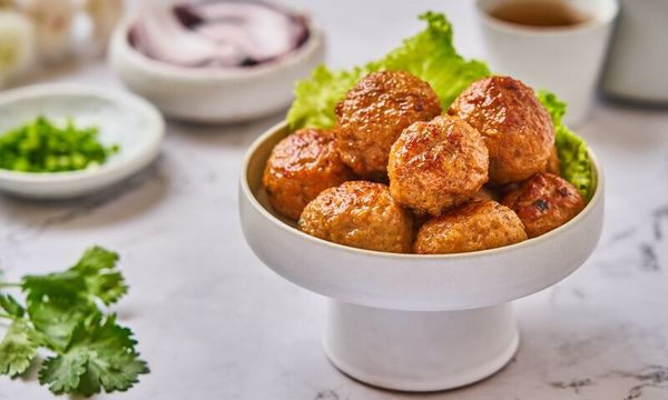 Ciotola con polpette dorate e cotte, servite su foglie di lattuga