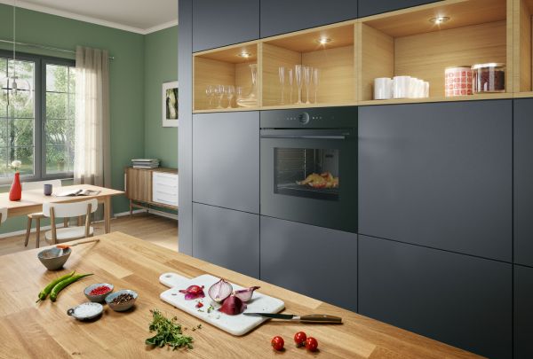 מטבח מודרני עם ארונות מטבח שחורים ובהם תנור בוש בצבע שחור