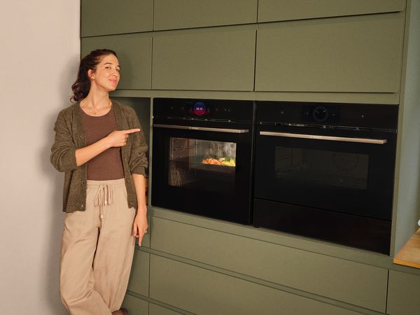 Imagen de una chica junto a un horno y un microondas Bosch Serie 8.