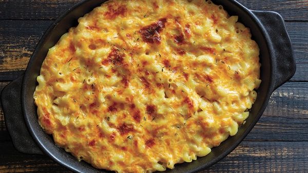 Baked macaroni and cheese with a golden‑brown cheesy crust in a black baking dish.