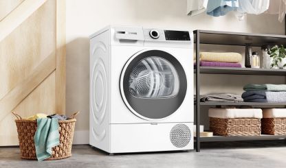 Witte Bosch warmtepompdroger in een wasruimte.         
