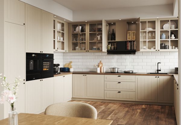 Bilden visar ett beige k&ouml;k (IKEA-inspirerat) i lantlig stil, med integrerade vitvaror fr&aring;n Bosch.