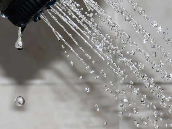 Primo piano del getto d&rsquo;acqua che esce da un soffione della doccia