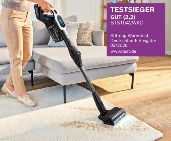 Eine Person reinigt mit dem Bosch Akku-Staubsauger Unlimited 10 BTS1042WAC (Testsieger der Stiftung Warentest) einen Teppich.
