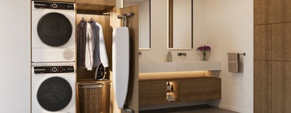 Bagno moderno in legno con zona lavanderia: lavatrice e asciugatrice Bosch a colonna e armadio con asse da stiro