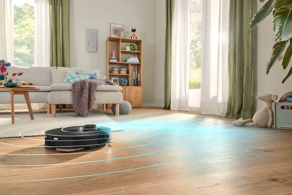 Robot aspirapolvere Bosch Spotless in funzione sul pavimento in legno del soggiorno 