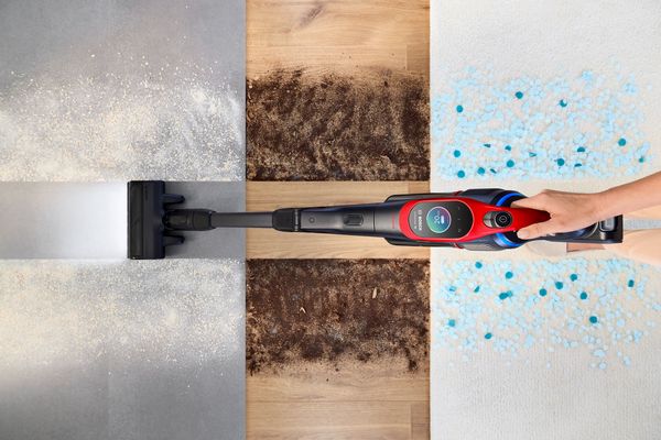 Vista dall&rsquo;alto di una scopa elettrica Bosch Unlimited in funzione che rimuove sporco e polvere da diverse superfici