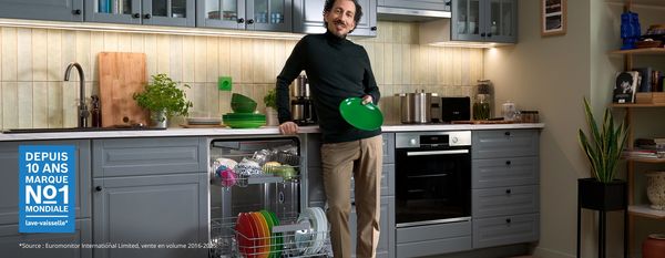 Homme tenant une assiette verte dans ses mains.