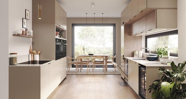 Modernt k&ouml;k i beige med inbyggda vitvaror fr&aring;n Bosch.