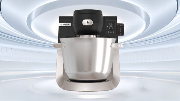 Bosch K&uuml;chenmaschine mit Edelstahlsch&uuml;ssel und Bedienfeld vor futuristischem Hintergrund.