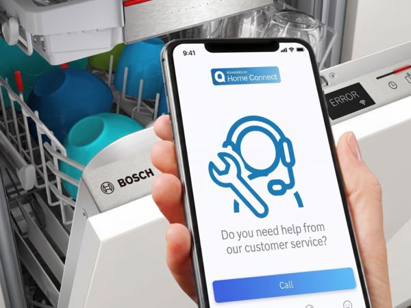 Hand h&auml;lt Smartphone mit Kundenservice-App vor offenem Bosch‑Geschirrsp&uuml;ler, Hilfe-Button und Fehleranzeige sichtbar.