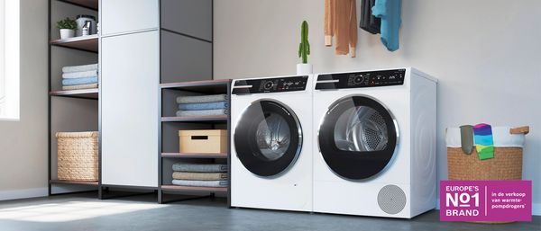 Heldere, moderne wasruimte met witte wasmachine en droger, rekken en betegelde vloer.