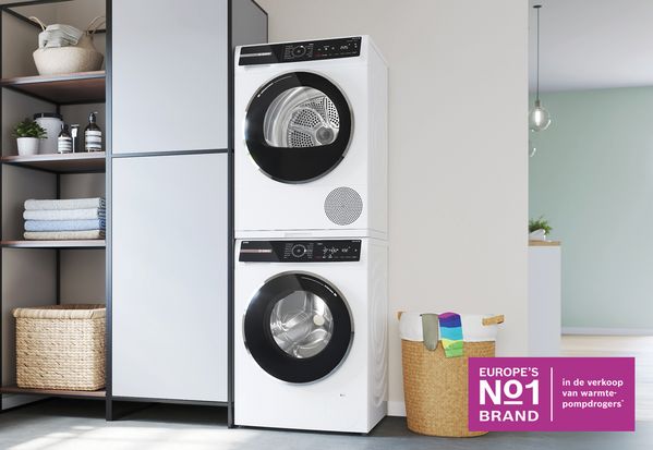 Een wasmachine en droger op elkaar in een kleedruimte.