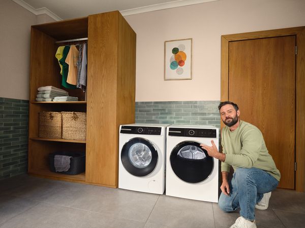 Gezellige wasruimte met wasmachine, droger, planken en inrichting.