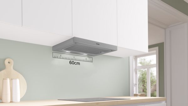 Cuisine moderne avec hotte Bosch de 60 cm, plan de travail en bois clair et meubles blancs minimalistes.