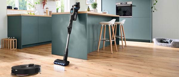 robot sprzatajacy i odkurzacz pionowy w kuchni