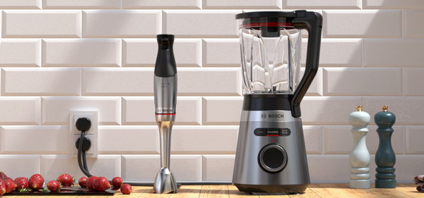 Frullatore e mixer a immersione Bosch su un piano di lavoro con fragole fresche, decorazione moderna e logo di garanzia