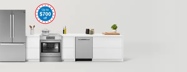 Modern kitchen with matching fridge, cooker and microwave surrounded by sleek cabinets in warm wood and an off-white tone