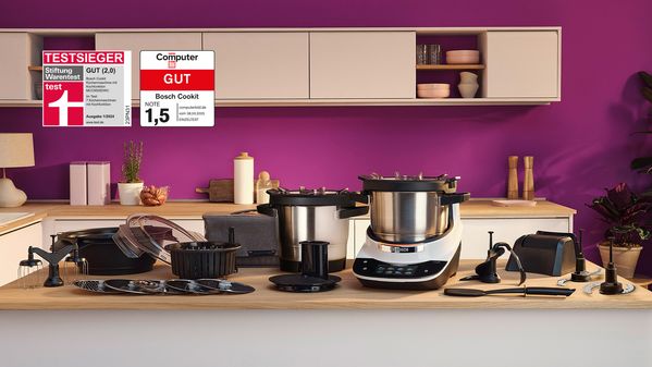 Bosch Cookit K&uuml;chenmaschine mit Kochfunktion und umfangreichem Zubeh&ouml;r auf der Arbeitsfl&auml;che, ausgezeichnet als Testsieger von Stiftung Warentest.