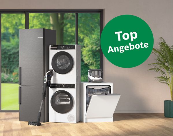 Bosch K&uuml;hlschrank, Waschmaschine, Trockner, Geschirrsp&uuml;ler mit offener T&uuml;r, Handstaubsauger und K&uuml;chenmaschine vor gro&szlig;em Fenster mit Blick ins Gr&uuml;ne und gr&uuml;nem Kreis mit Text 'Top Angebote'.