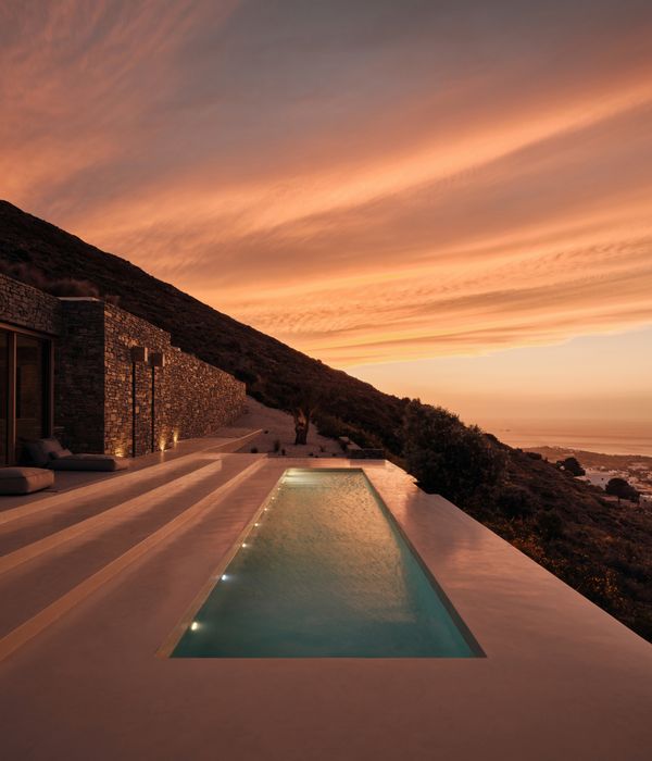Exterior shot looking across the pool showing a red sunset and dramatic scenery 