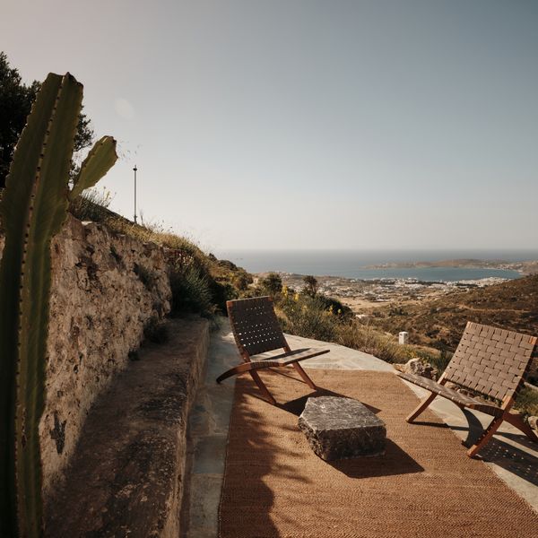 Exterior shot of the shepherds shed showing some garden chairs and view of the coastline 