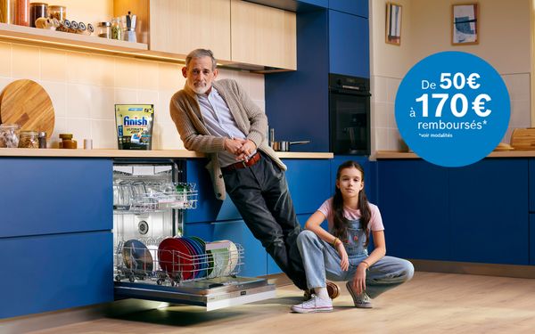 Homme &acirc;g&eacute; et petite fille dans une cuisine moderne. Lave-vaisselle ouvert. 