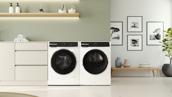 Bosch Serie 8 wasmachine met i-DOS staat naast een droger. Er staat een kleine cactus op met zijn duim omhoog.