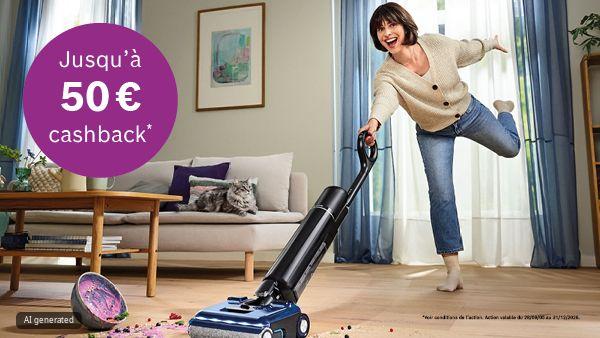 Femme balaie joyeusement des d&eacute;bris color&eacute;s sur le sol en bois avec un nettoyeur &eacute;lectrique ; un chat est pos&eacute; sur le canap&eacute;. En haut &agrave; gauche, un cercle violet portant l'inscription "Tot 50&euro; cashback".