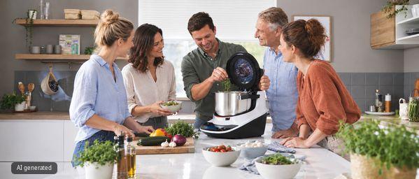 F&uuml;nf Freunde kochen gemeinsam mit der Bosch Cookit K&uuml;chenmaschine mit Kochfunktion in einer hellen K&uuml;che.