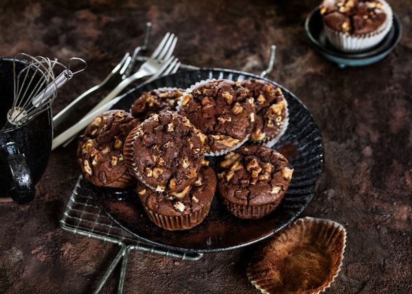Muffin al cioccolato con pezzi di cioccolato e frutta secca serviti su un piatto scuro