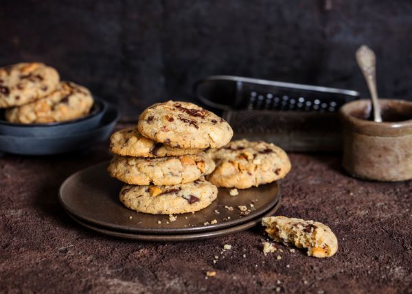 Biscotti con gocce di cioccolato impilati su un piatto scuro