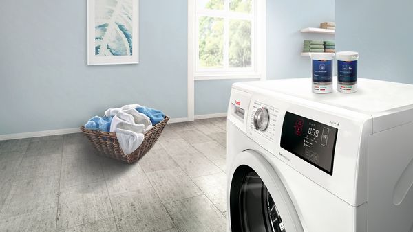 Rengjøringsprodukter for vaskemaskin på toppen av en vaskemaskin.   