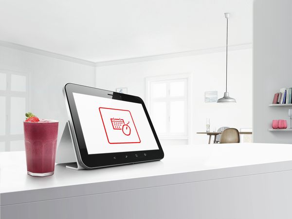 Tablet auf einer Kücheninsel mit einem Symbol für das Bosch Tool für die Online-Terminvereinbarung auf dem Bildschirm. 