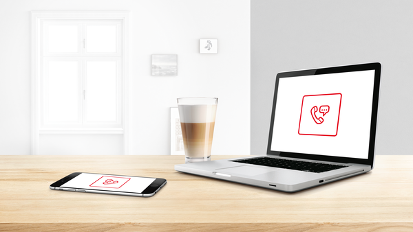Лаптоп и телефон с икона за контакт върху работен плот