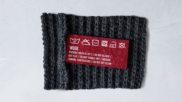 Capo in lana con etichetta con simboli di lavaggio
