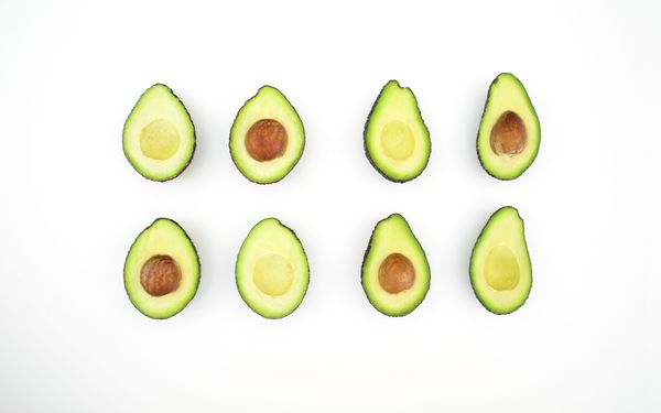 An arrangement of perfectly shaped and half-cut avocados.